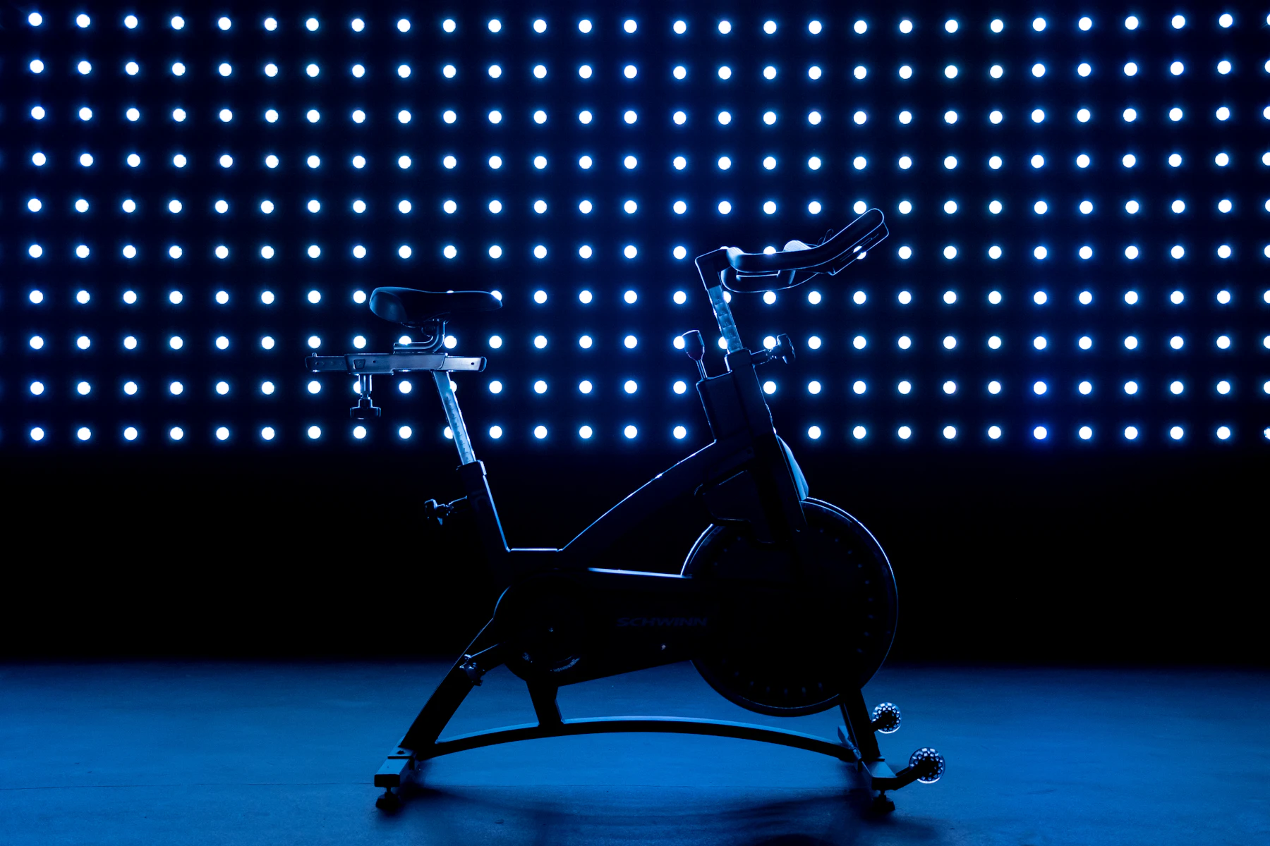 A real indoor cycling bike under blue studio lights
